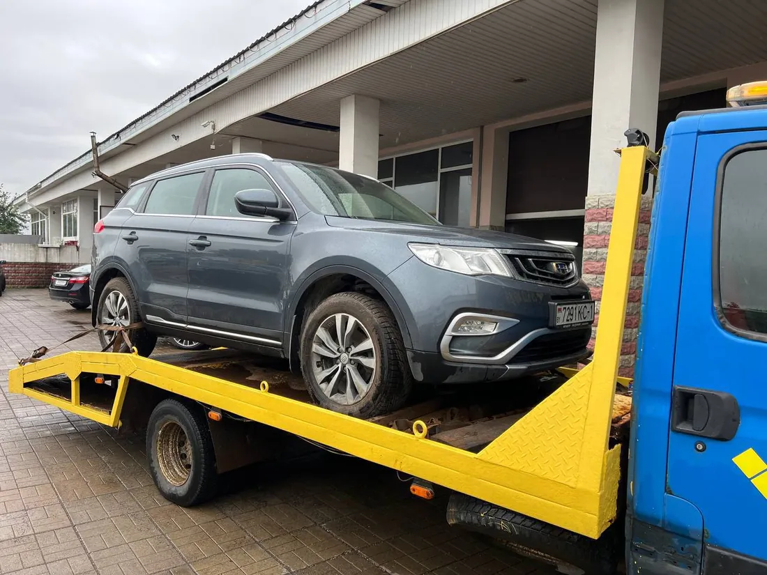 Погрузка автомобиля Geely на платформу эвакуатора для доставки в сервис в Минске